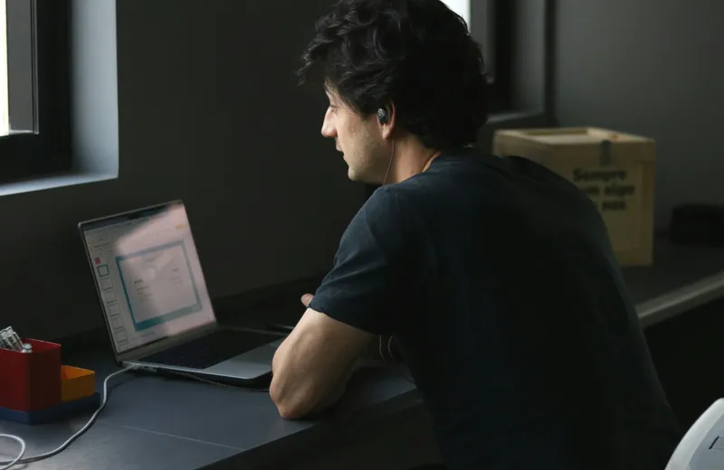 A person working at a laptop in a small office