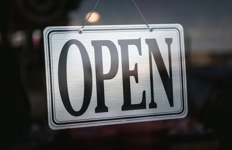 An open sign hanging in a shop door