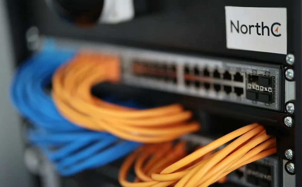 Blue and orange network cables patched into a rack switch